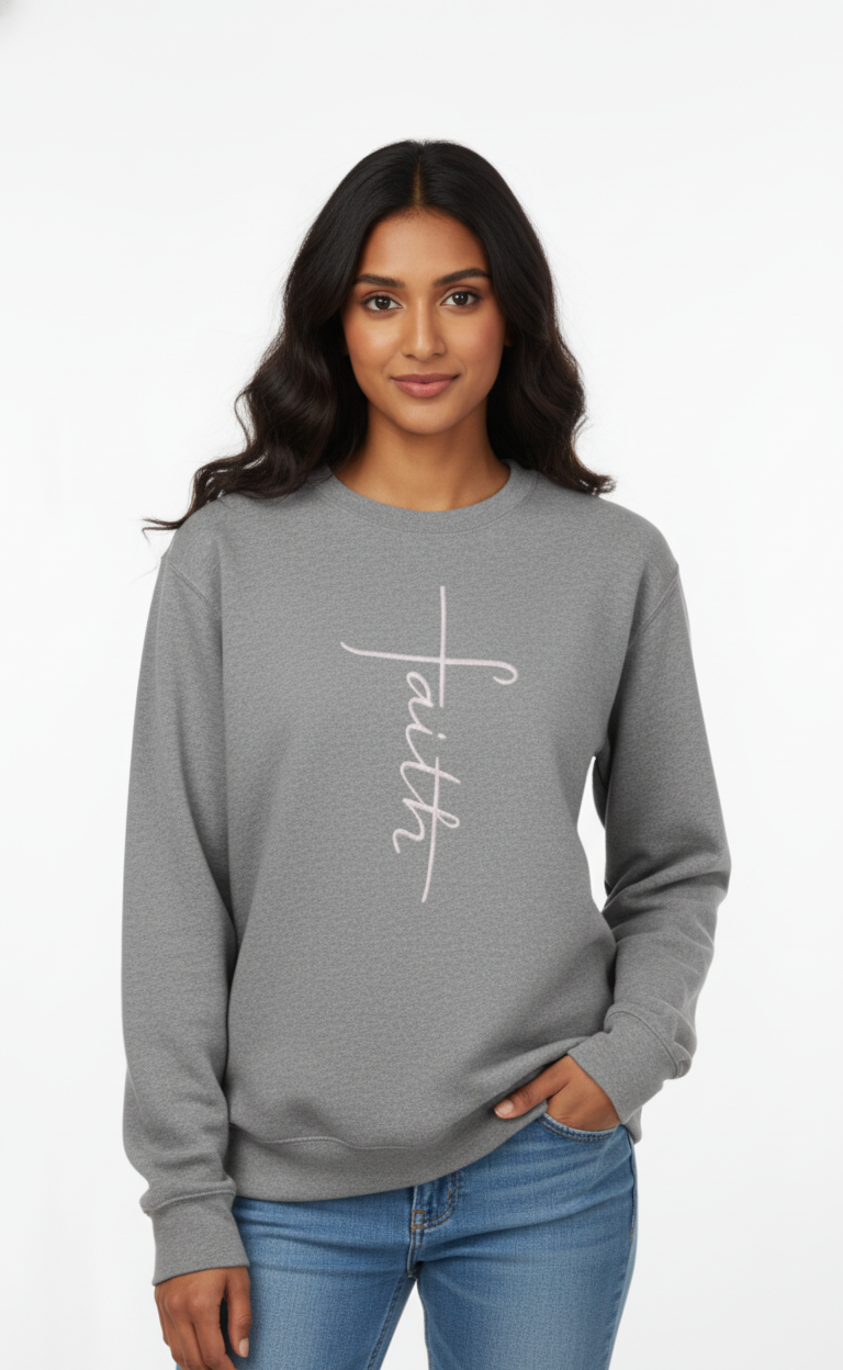 Woman wearing a gray sweatshirt with 'faith' embroidered on it against a white background