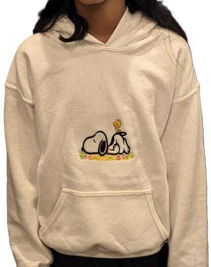 Beige hoodie with Snoopy cartoon character design embroidered on a white background