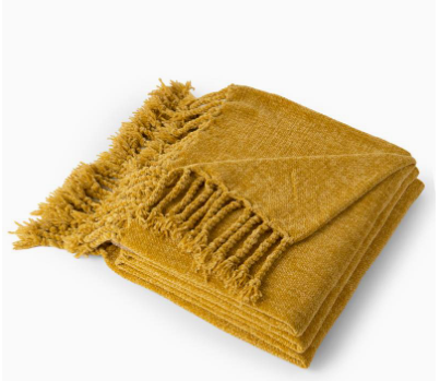 Mustard yellow blanket with frayed edges on a white background