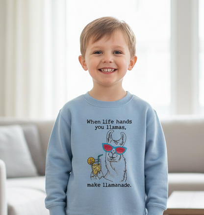 Child wearing a blue sweatshirt with a llama graphic and text embroidered on it